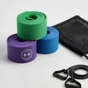 Three pastel-colored non-slip fabric monster bands rolled up next to a black mesh travel pouch.